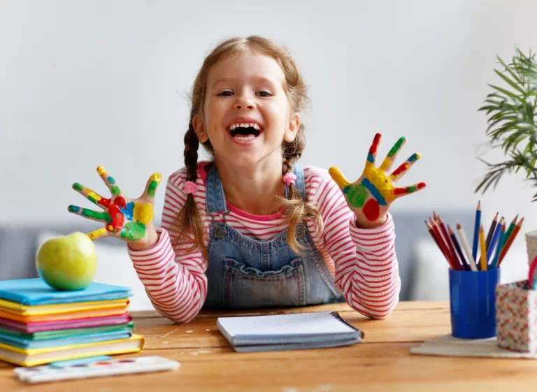 dziewczynka z pomalowanymi farbami dłońmi